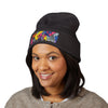 Person wearing a black beanie with colorful design on a white background