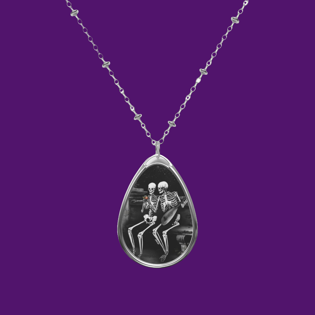 Teardrop-shaped pendant with skeleton design on a purple background