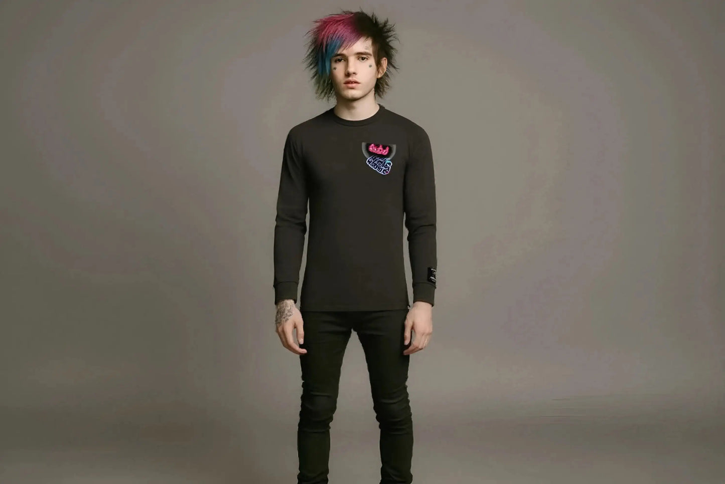 Person wearing a black long-sleeve shirt with a colorful design on a gray background