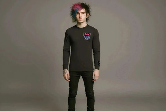 Person wearing a black long-sleeve shirt with a colorful design on a gray background