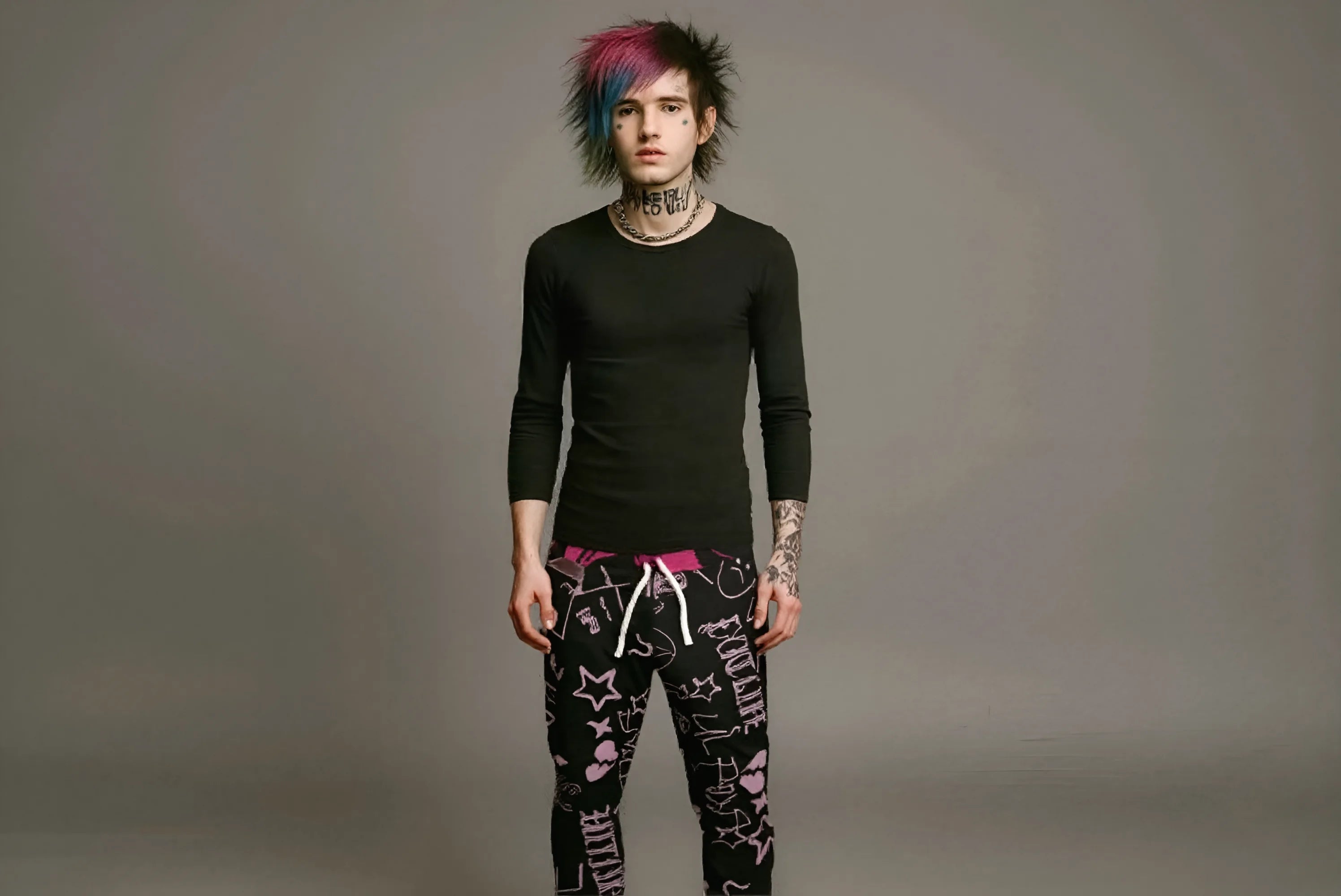 Person wearing a black long-sleeve top and patterned pants on a gray background